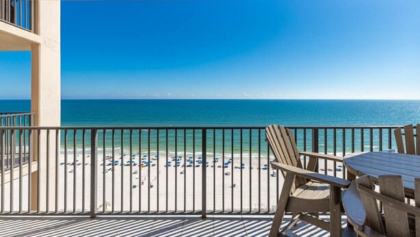 Un balcon avec vue sur une plage et l’océan.