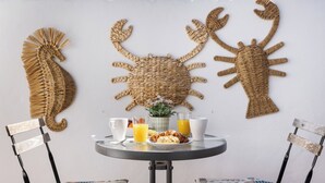 A round table with a plate of food, two glasses of orange juice, and a white mug. - Orquidea Apartment - Historical Center (Málaga)