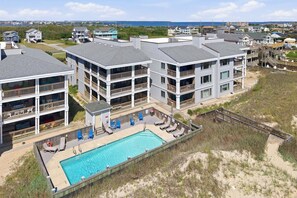 Un hôtel à plusieurs étages doté d'une piscine et d'un accès à la plage.
