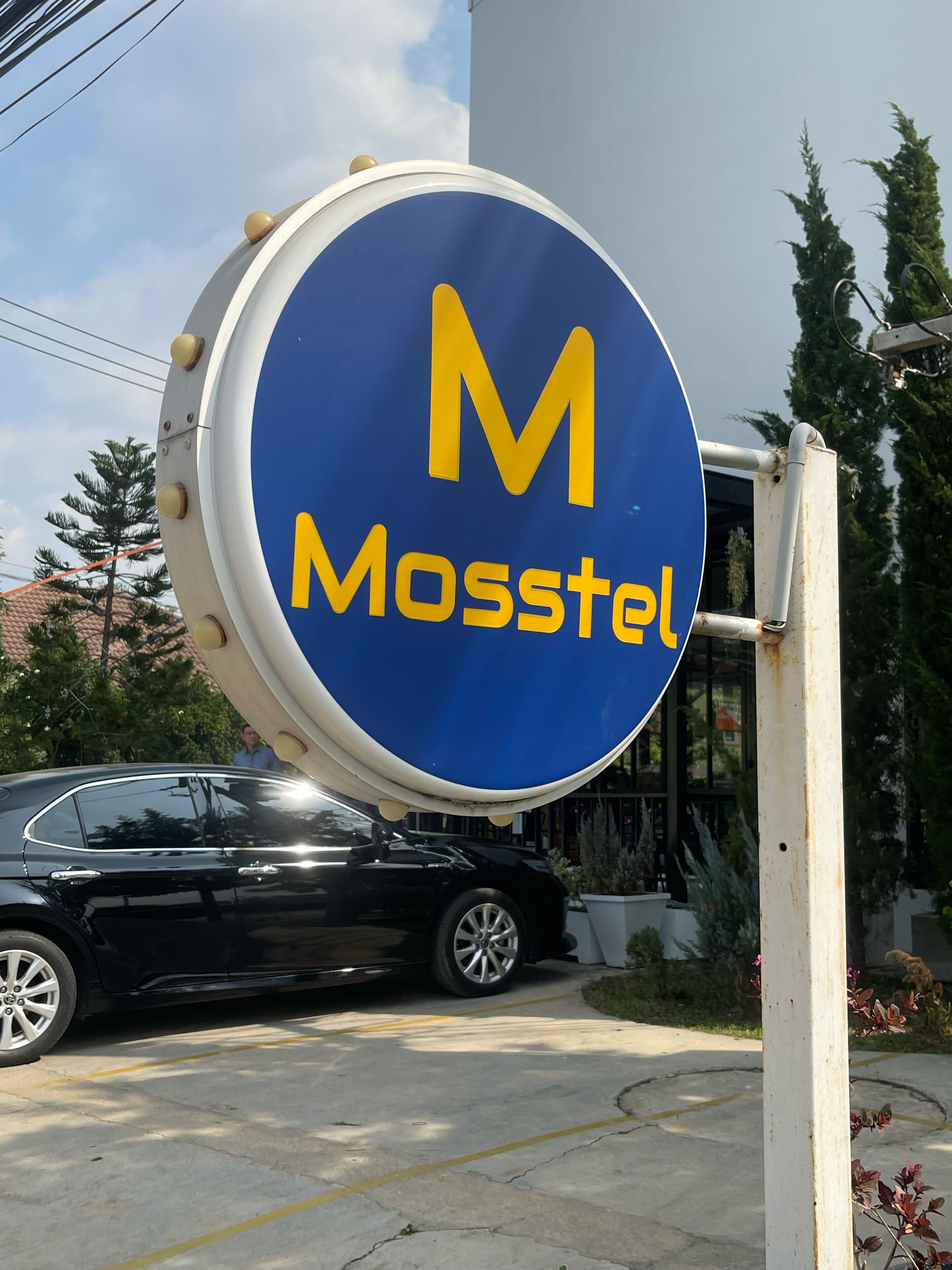 A blue sign with the logo and name "Mosstel" on a building.