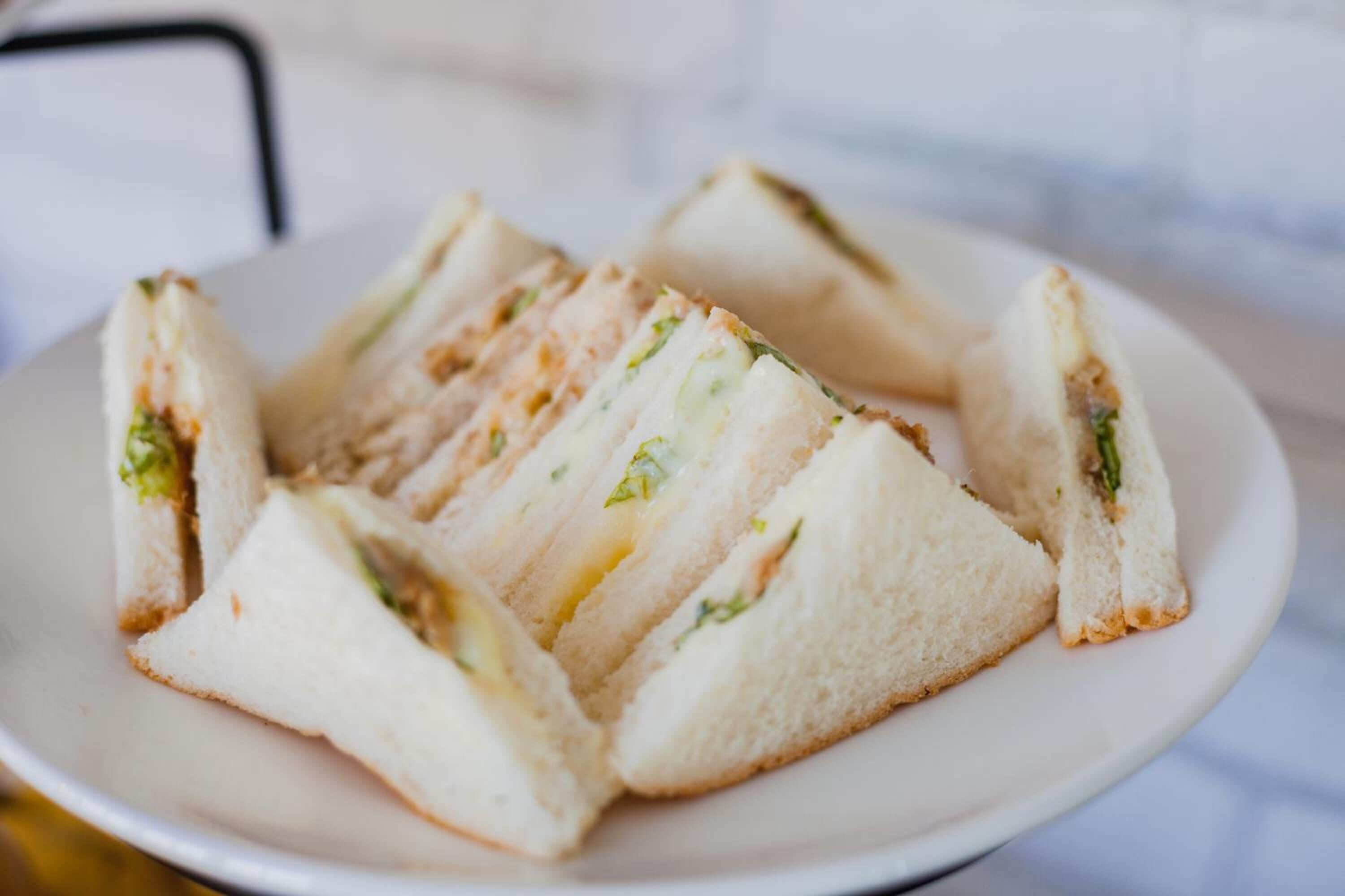 Une assiette de sandwichs coupés en triangles.