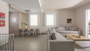 Een moderne woonkamer met een bank, een salontafel en een eethoek met krukken.