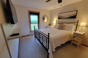 A bedroom with a bed, bedside tables, a TV, a window, and a painting on the wall. - Sky Ridge - Stunning Mountain Top Views, Hot Tub (Davis)
