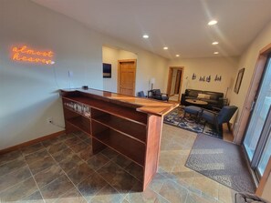 A spacious room with a wooden desk, a sofa, and a dining area. - Sky Ridge - Stunning Mountain Top Views, Hot Tub (Davis)