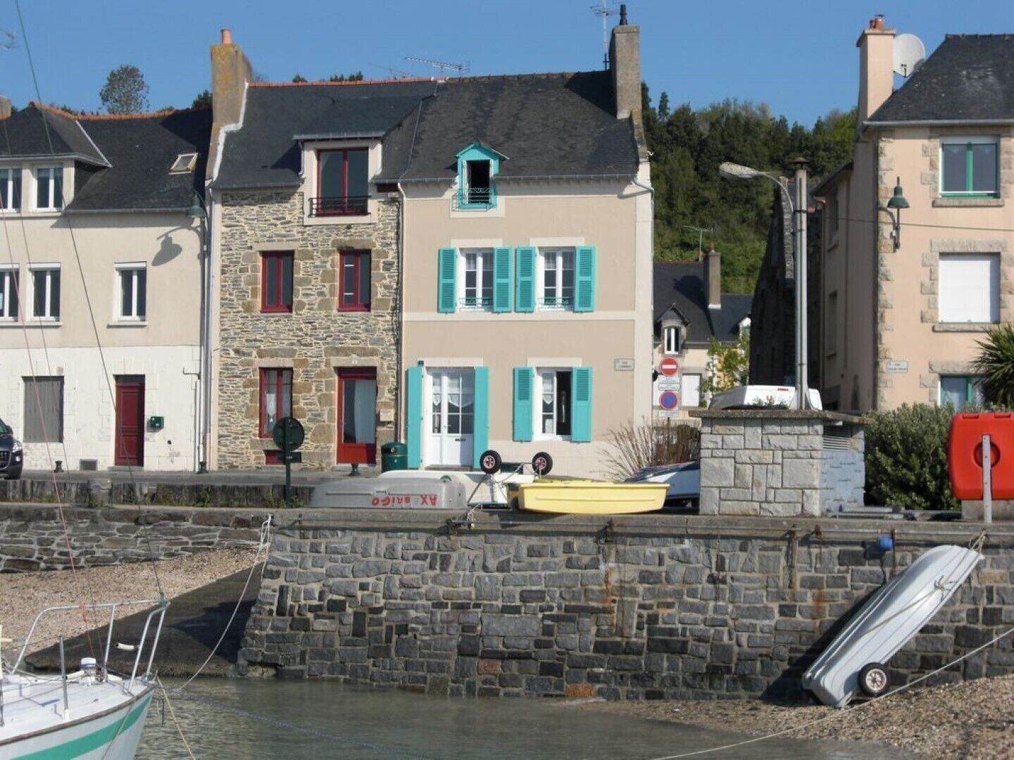 A coastal town with stone buildings, a dock with boats, and a stone wall.