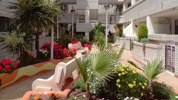 A multi-level atrium with balconies, outdoor seating, and a variety of plants. - Perfect views and location (Oropesa)