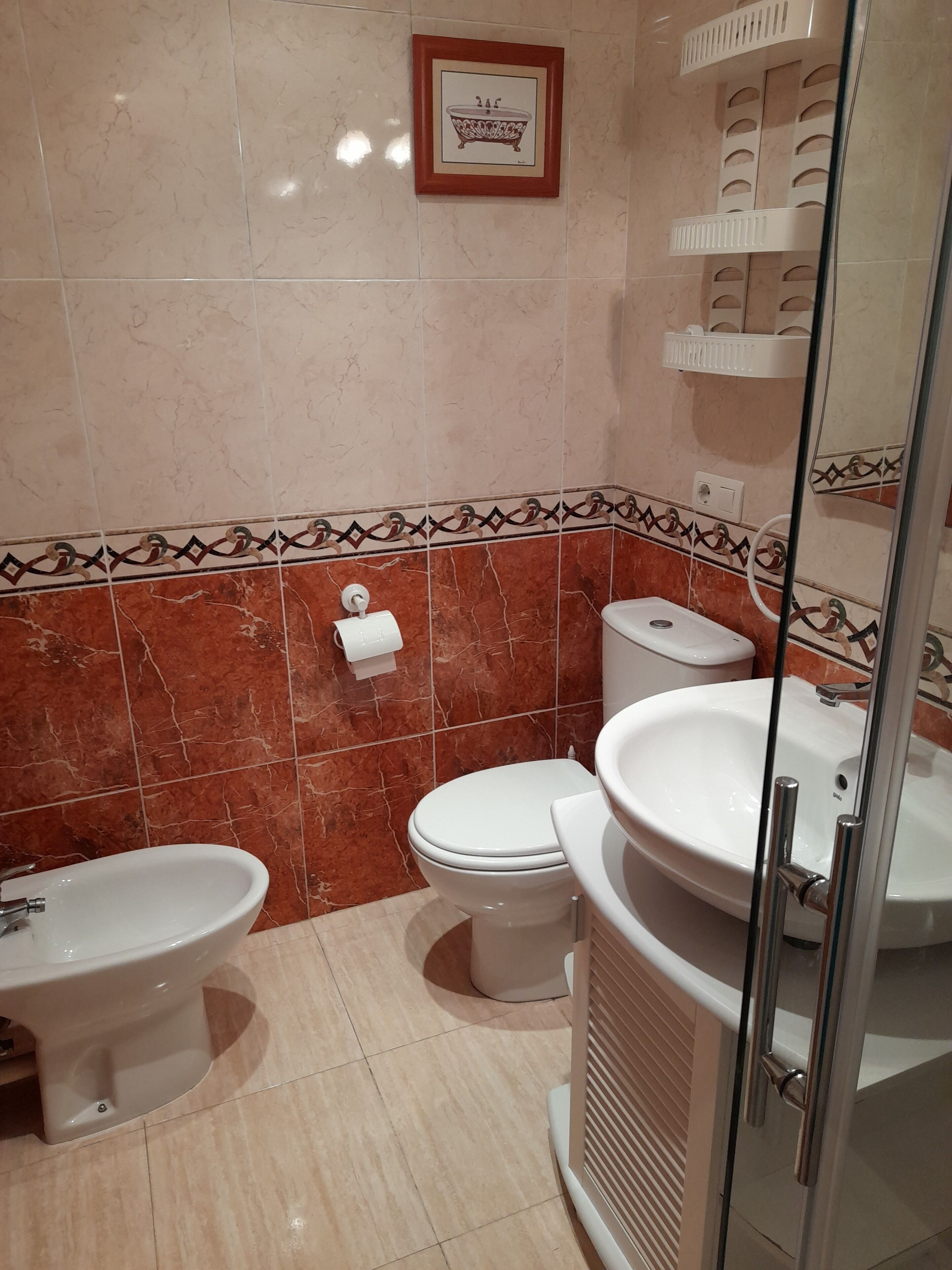 A bathroom with a toilet, bidet, and sink.