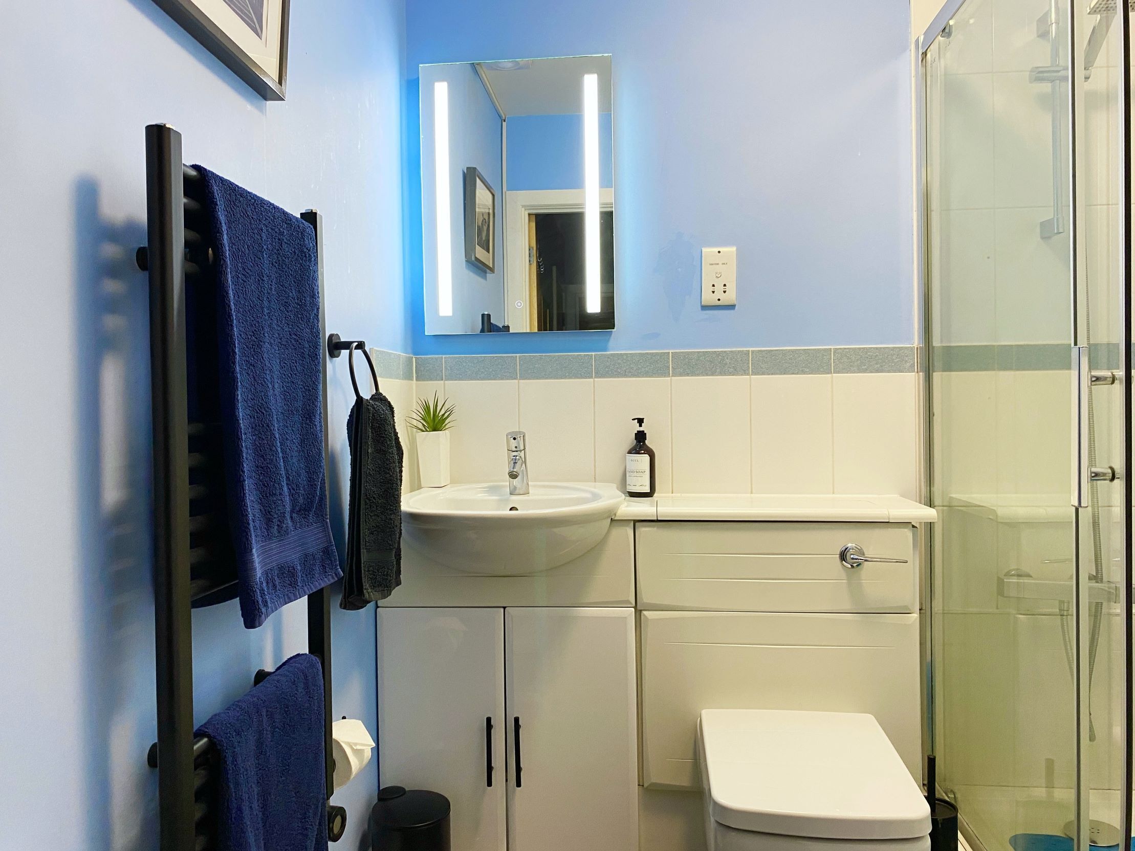 A bathroom with a sink, toilet, and shower.