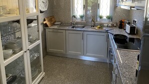Et moderne køkken med granitbordplader, hvide skabe og en indbygget ovn.