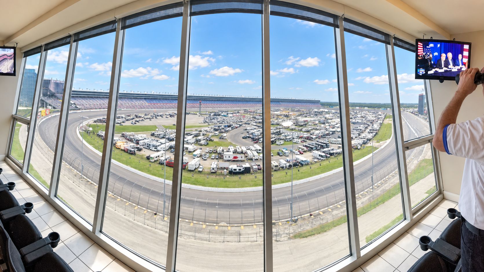 Une grande fenêtre donnant sur un circuit automobile et un parking.