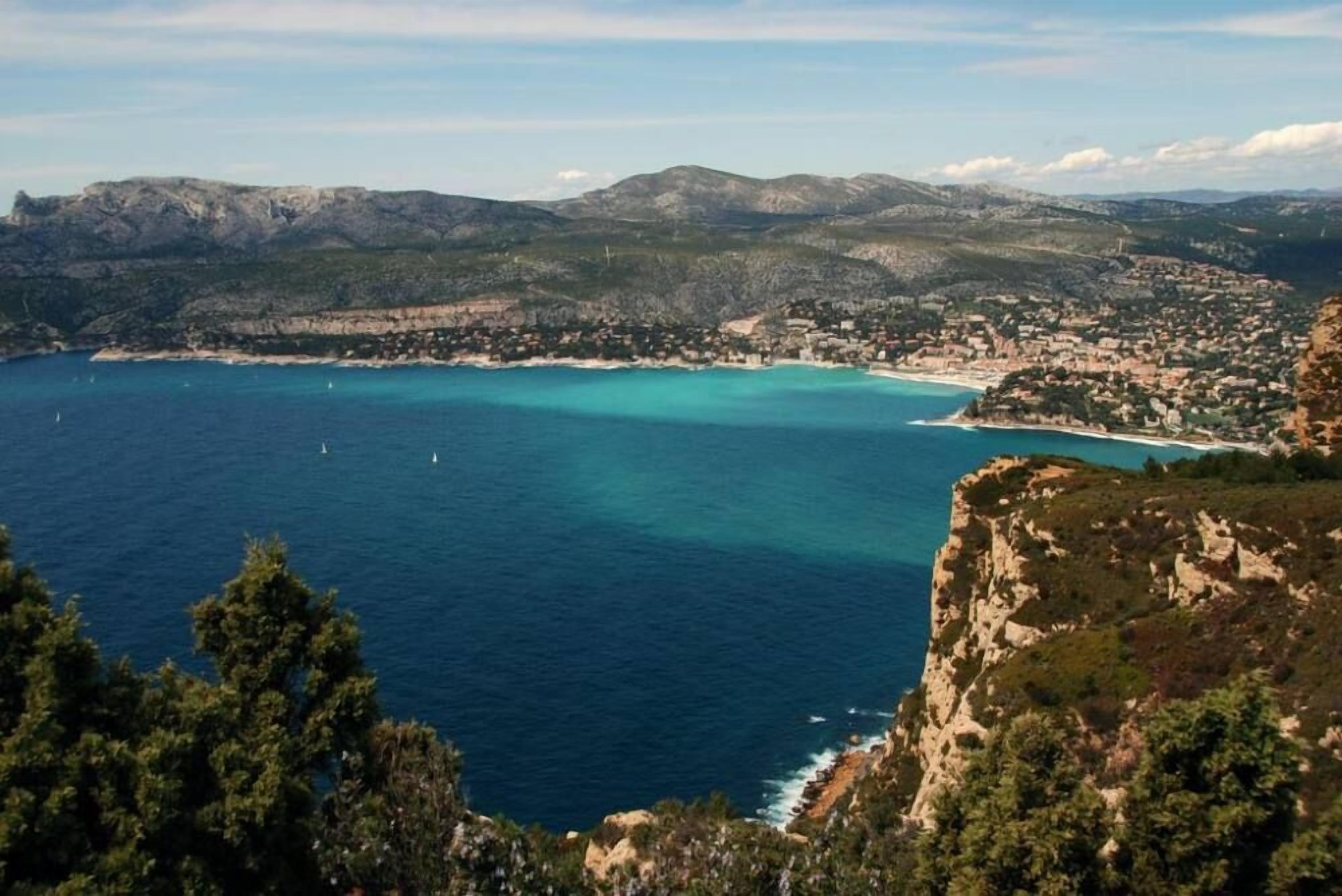 A coastal town with a clear view of the sea and surrounding hills.
