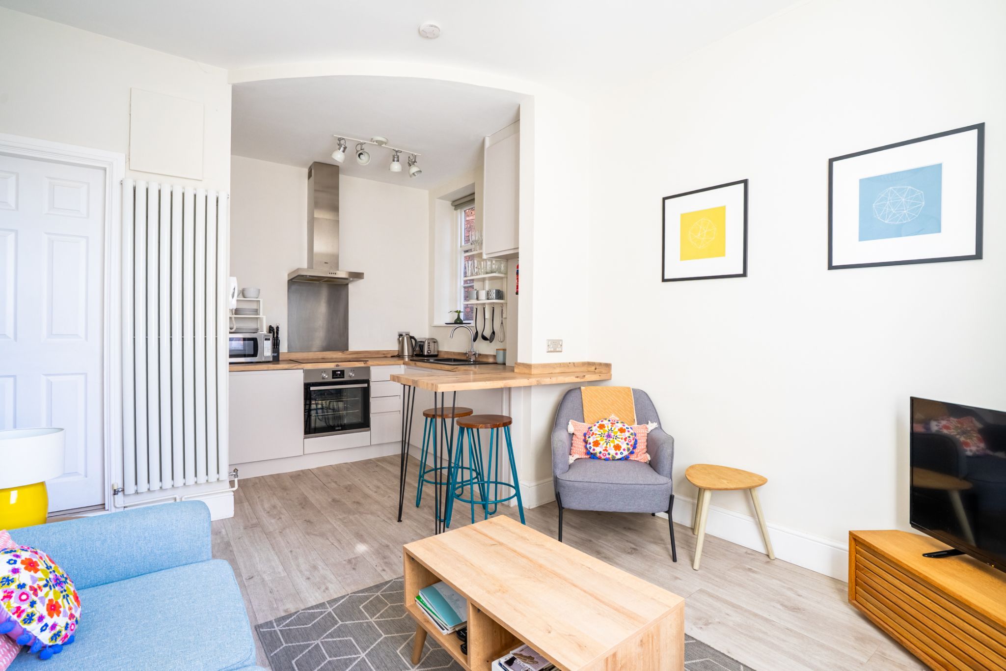 A modern apartment with a kitchen, a living area, and a dining space.