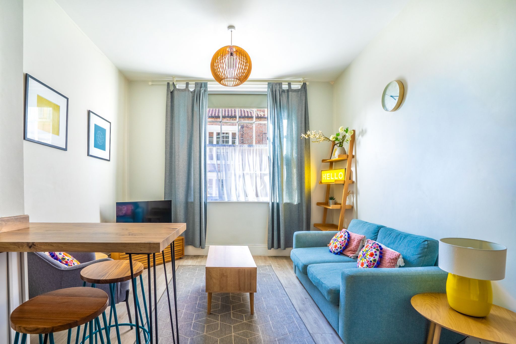 A modern living room with a sofa, coffee table, and a dining area with chairs.