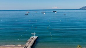Un muelle se adentra en aguas azules y tranquilas, con varias embarcaciones ancladas cerca.