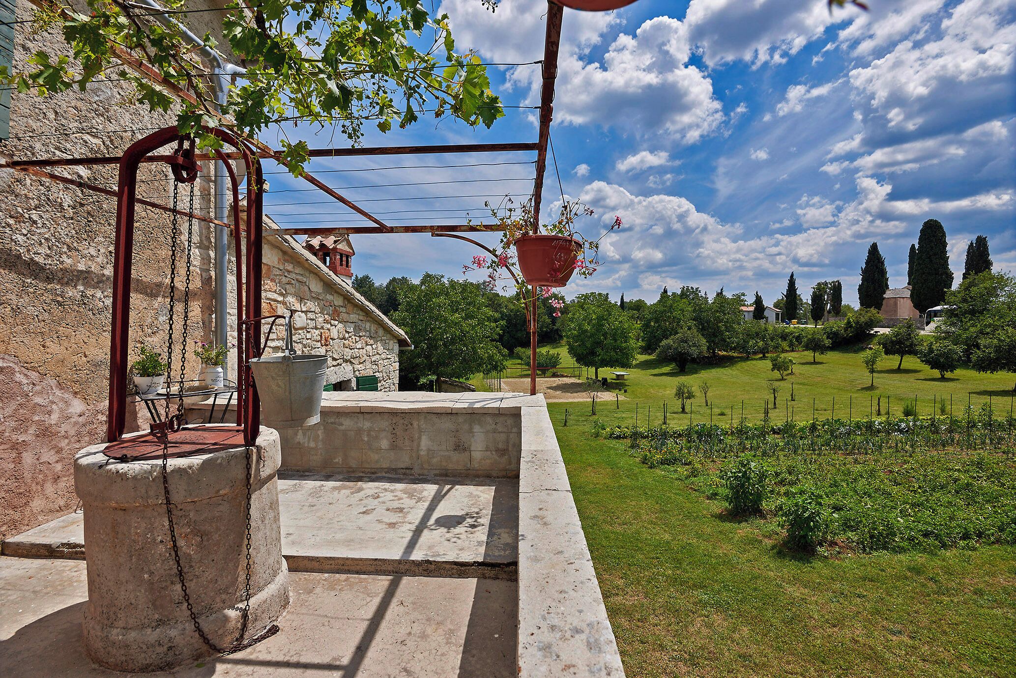 A stone building with a garden in the background.