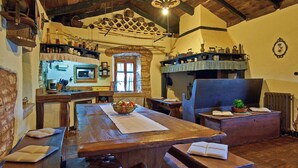 A rustic dining area with a wooden table, benches, and a stone archway. - Holiday house Stara Hiža * large garden, private pool, free WiFi (Sveti Petar u Šumi)