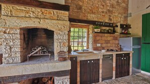 A rustic kitchen with a stone fireplace, wooden cabinets, and a built-in dishwasher. - Holiday house Stara Hiža * large garden, private pool, free WiFi (Sveti Petar u Šumi)