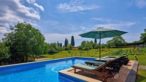 A swimming pool with lounge chairs and an umbrella, surrounded by greenery and a clear sky. - Holiday house Stara Hiža * large garden, private pool, free WiFi (Sveti Petar u Šumi)