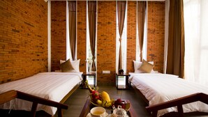 A hotel room with two beds, a breakfast tray with fruits, a cup, and a teapot. - Koki Tree (Siem Reap)