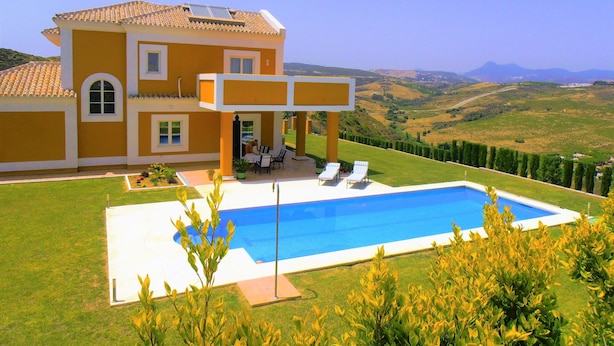 A two-story house with a swimming pool, a patio with chairs, and a view of the countryside. - luxury villa for 8 persons with private pool, panoramic views, WIFI (Manilva)