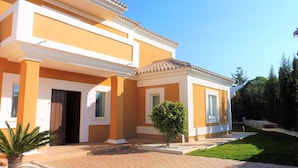 A two-story building with a tiled roof, a brick pathway, and a small tree in the foreground. - luxury villa for 8 persons with private pool, panoramic views, WIFI (Manilva)
