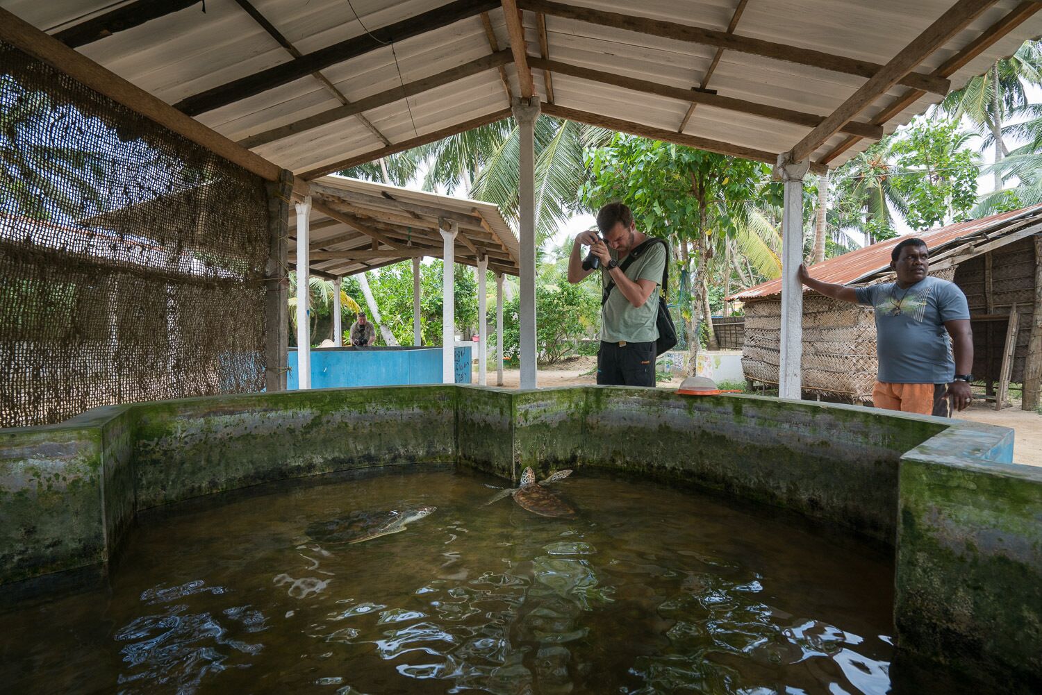 A covered outdoor area with a water feature and a person taking a photo.