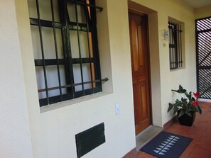Stunning building facade with a welcoming entrance, complete with a potted plant and a decorative mat.