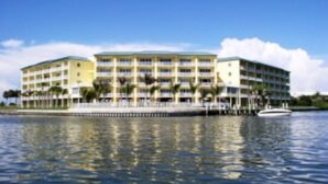 Un hotel de varios pisos con balcones, situado junto al agua.