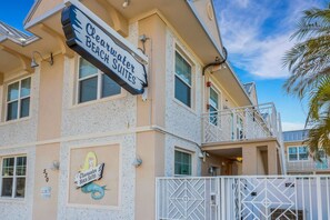 A building with a sign for 'Clearwater Beach Suites' and a mermaid logo. - Stunning beach condo with heated pool and in-unit washer/dryer, steps to sand! ➠ CBS 107 (Clearwater)