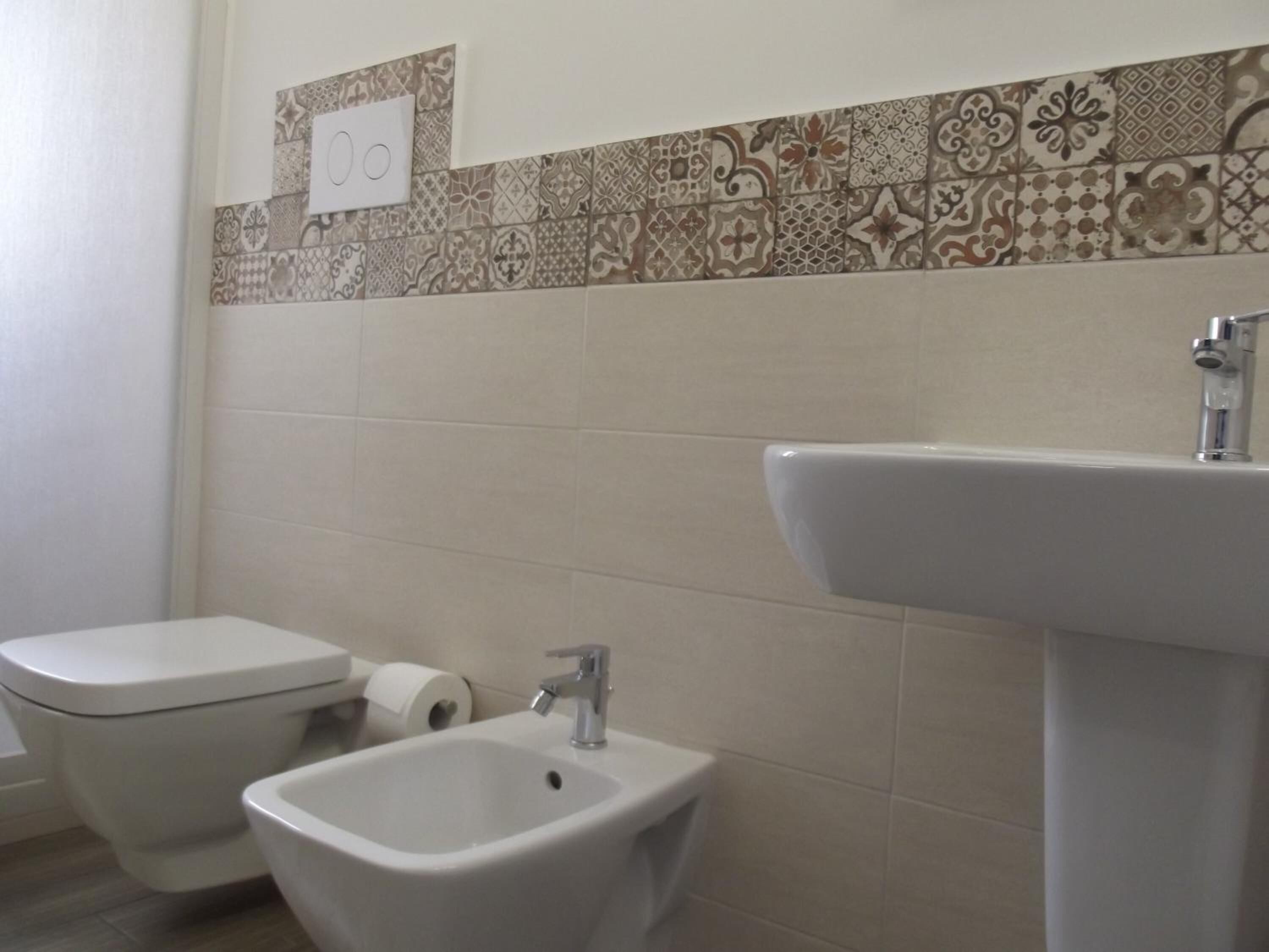 A bathroom with a toilet, bidet, and sink.