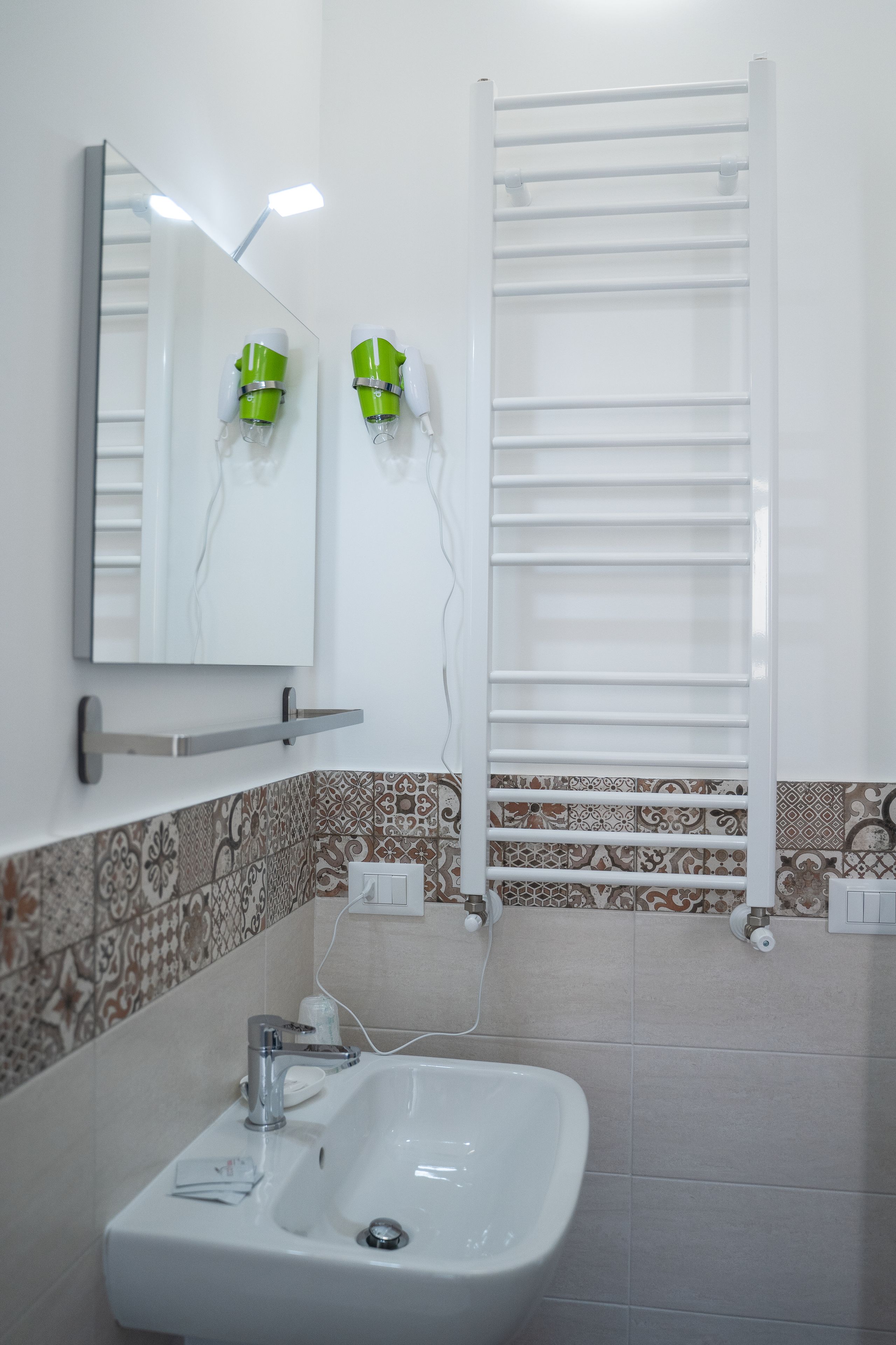 A bathroom with a white sink, a mirror, and a towel rack.