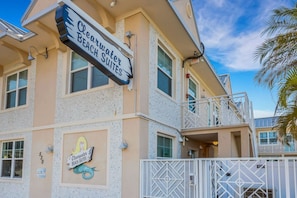 A building with a sign for 'Clearwater Beach Suites' and a mermaid logo. - 🌴 Ground Floor Condo @ Clearwater Beach Suites | Steps to Sand • Heated Pool ➠ CBS 102 (Clearwater)