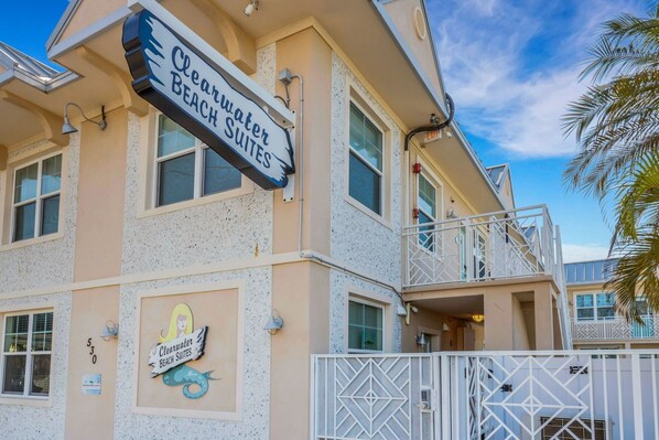 Un edificio con un letrero que dice 'Clearwater Beach Suites' y un logotipo de sirena.