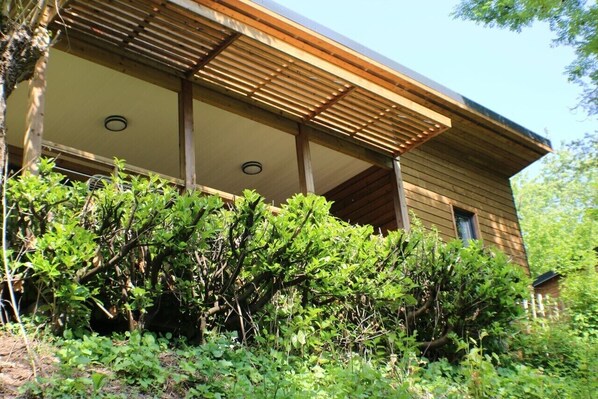 Un bâtiment en bois doté d’un toit en pente et d’un porche abrité.