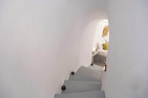 A white staircase with a small table and a lamp at the top.