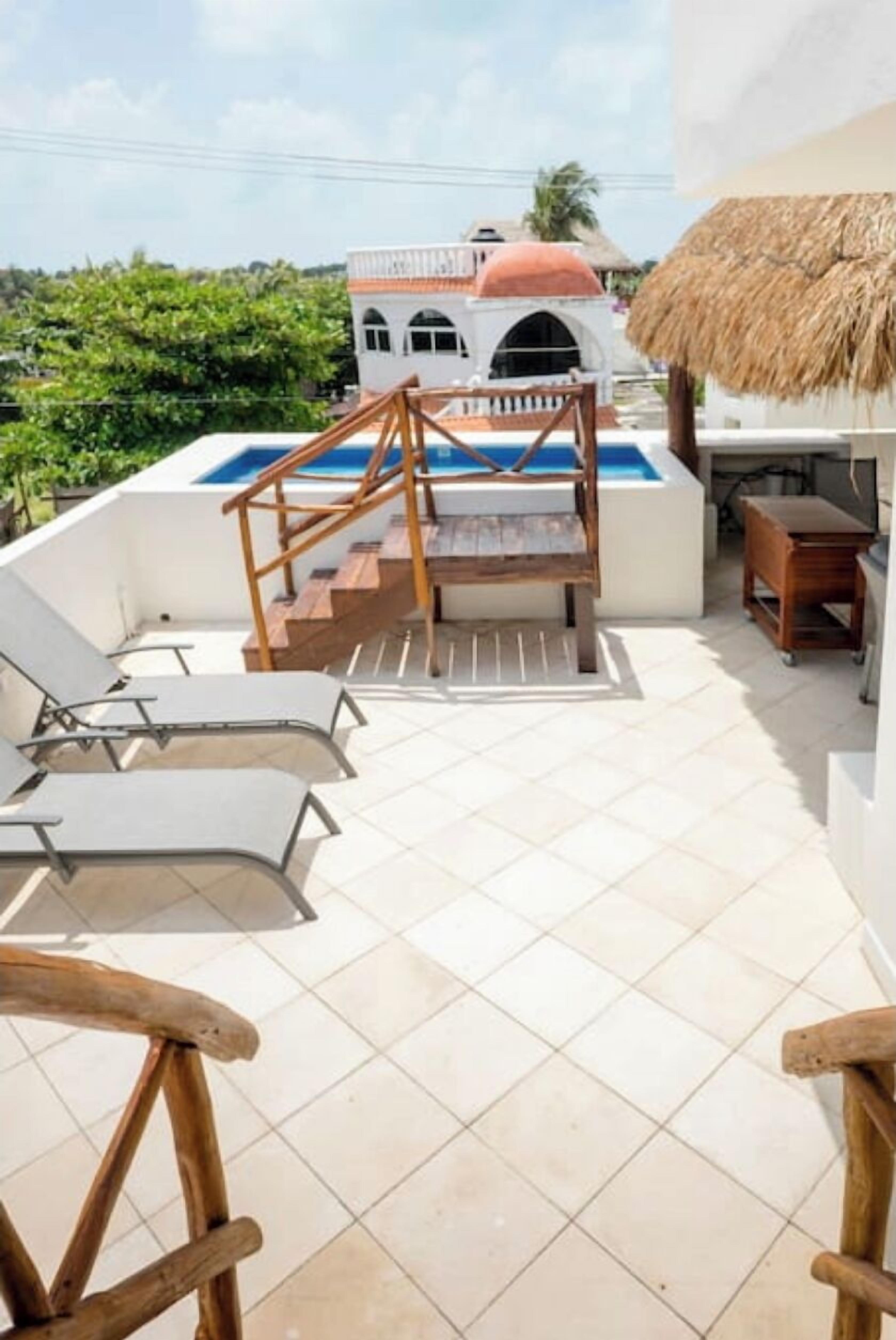 Zona de piscina exterior con una escalera que lleva a un edificio de techo con cúpula roja.
