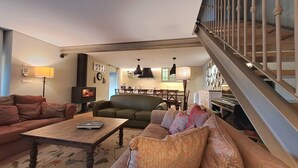 A living room with a sofa, a coffee table, a fireplace, and a staircase.