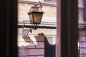 Un luminaire suspendu, fixé à la façade d’un bâtiment.
