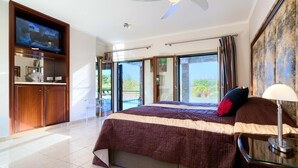 A spacious bedroom with a large bed, a television, and a view of the outdoors. - Villa 141 Rio - Five Bedroom Villa, Sleeps 10 (Kouklia)