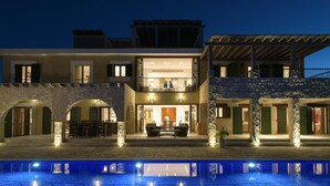 A two-story building with a pool, stone arches, and a covered patio area. - Villa 141 Rio - Five Bedroom Villa, Sleeps 10 (Kouklia)
