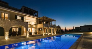 A two-story house with a swimming pool, stone arches, and outdoor seating. - Villa 141 Rio - Five Bedroom Villa, Sleeps 10 (Kouklia)