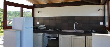 A compact kitchen with a built-in oven, a sink, and a refrigerator.