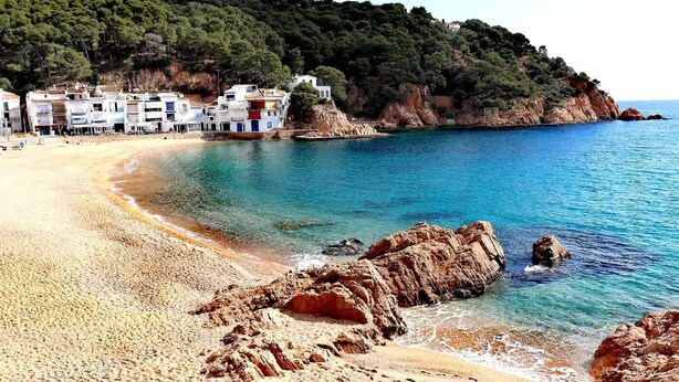 A coastal beach with rocky formations and a row of white buildings with balconies. - CASA DEL MAR 50m from the beach (Tamariu)