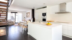 A modern kitchen with a central island, white cabinetry, and stainless steel appliances. - CASA DEL MAR 50m from the beach (Tamariu)