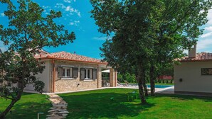 A house with a stone facade, a tiled roof, and a stone pathway leading to the entrance. - Villa Monte in Breg (Haus für 6 Personen) (Labin)
