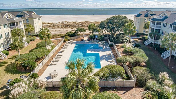 A resort with a swimming pool, beachfront view, and multiple buildings. - Port O'Call B 203, Direct Ocean View! (Isle Of Palms)