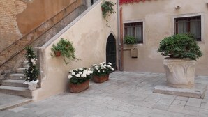 A courtyard with a staircase, potted plants, and a door. - Sunny, quiet flat in the heart of Venice, near Rialto Bridge (Venezia)