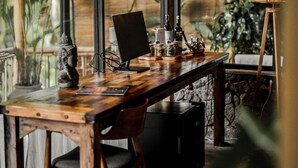 A wooden desk with a computer, a lamp, and various items.