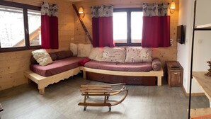 A cozy room with a wooden interior, a curved sofa, a wooden bench, and a small table.