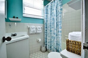 Tina con regadera, secadora de cabello, toallas 